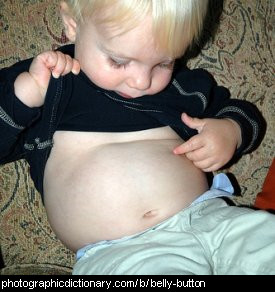 Photo of a small boy looking at his belly button