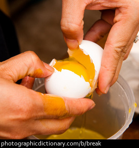 Photo of someone breaking an egg