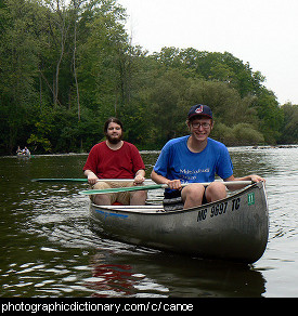 Photo of two men paddling a canoe