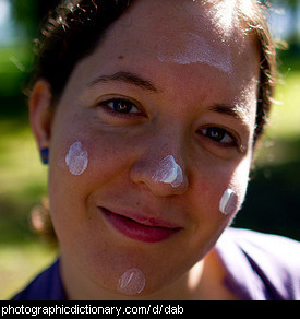 Photo of a woman with dabs of sunscreen on her face
