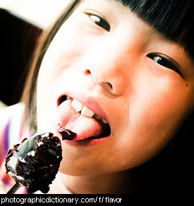 Photo of a girl licking chocolate icing.