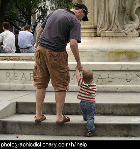 Photo of a man helping a toddler up some steps