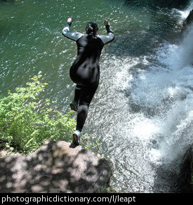 Photo of a woman leaping off a cliff