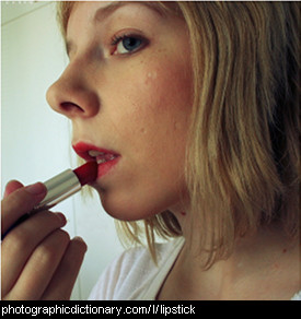 Photo of a woman applying lipstick
