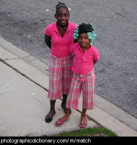 Photo of two girls in matching outfits.