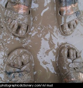 Photo of some people standing in mud.