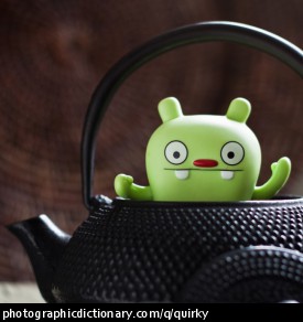 A quirky photo of a toy in a teapot.