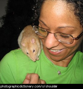 Photo of a woman with a rat on her shoulder.