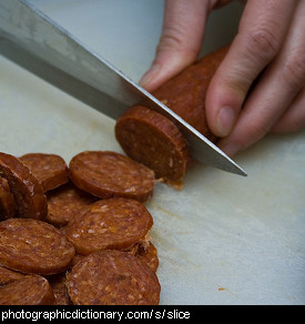 Photo of someone slicing pepperoni