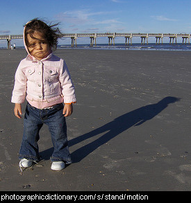 Photo of a little girl standing on a beach
