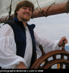 Photo of a man steering a ship