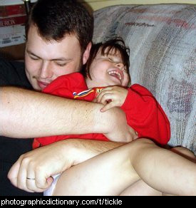 Photo of a father tickling their daughter