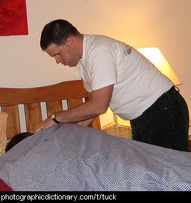 Photo of a man tucking his wife into bed