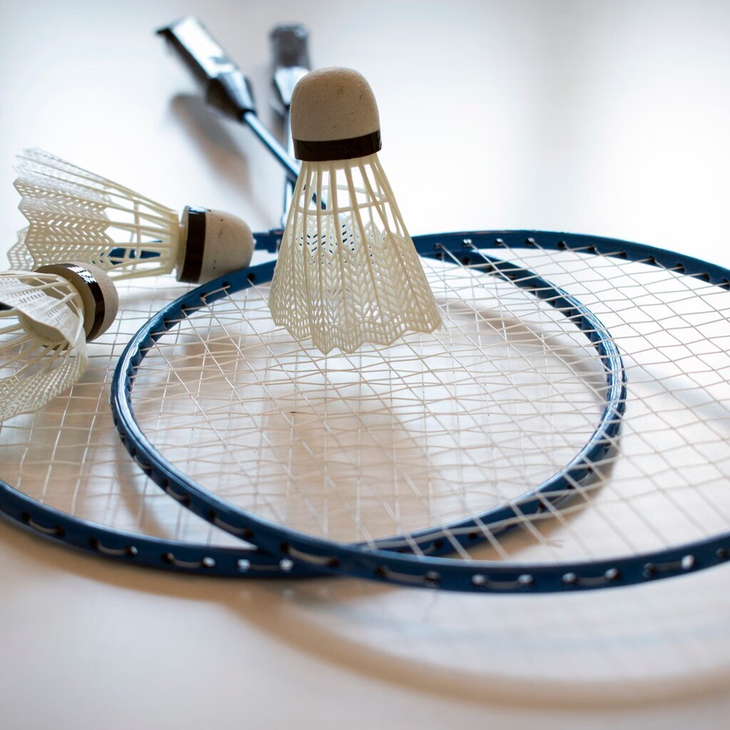 A photo of badminton rackets and shuttlecocks.