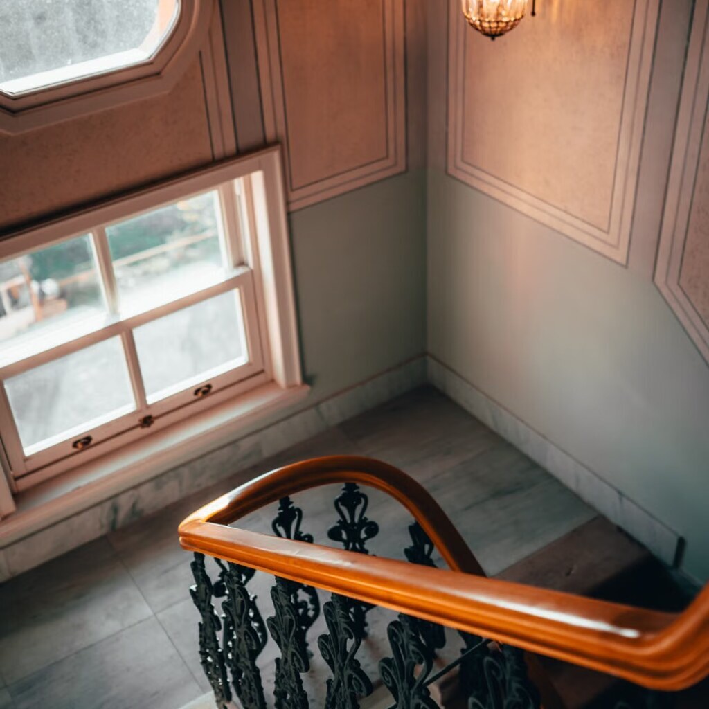 A photo of a wooden banister beside a staircase.