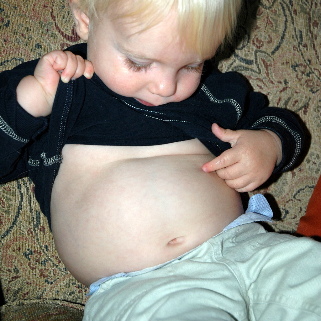 Photo of a small boy looking at his belly button