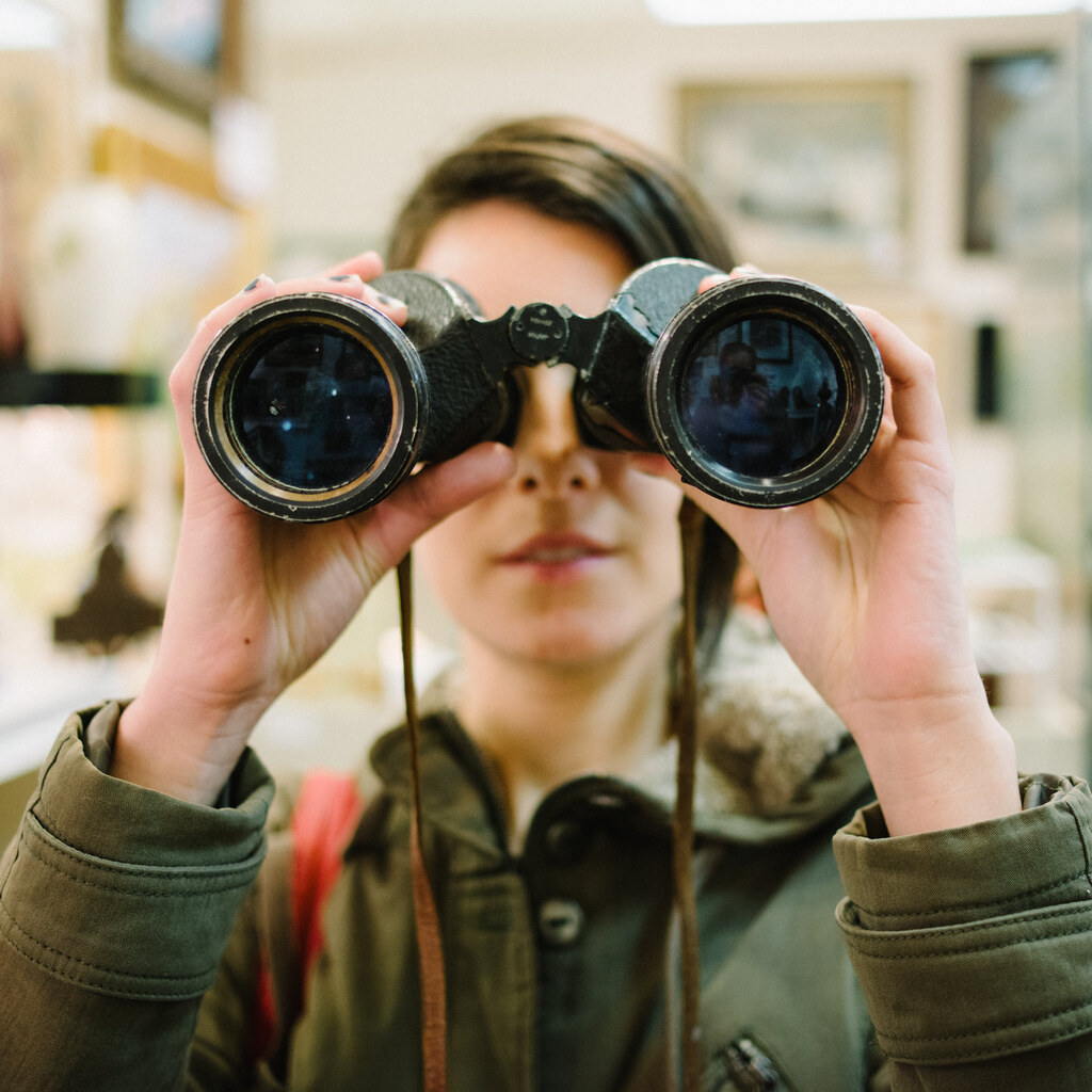Photo of a man looking through binoculars