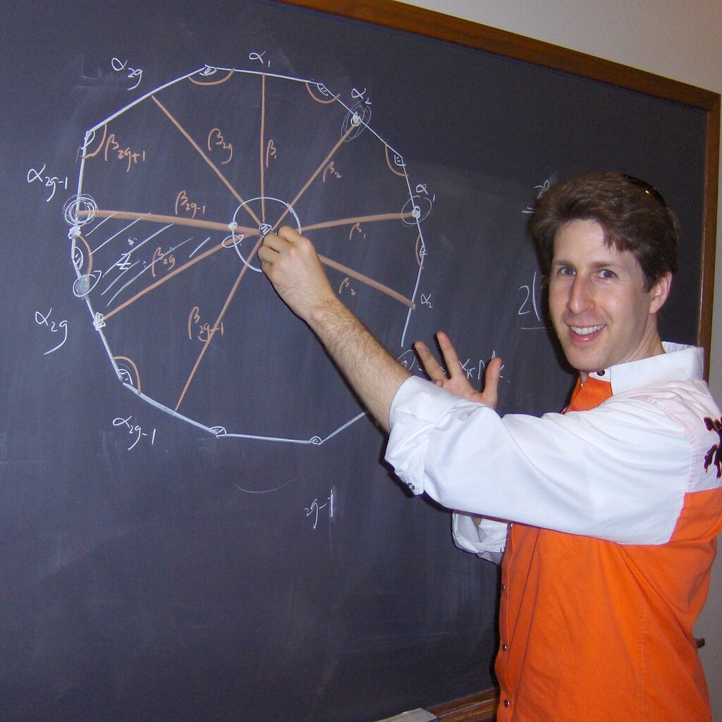 Photo of a man writing on a blackboard