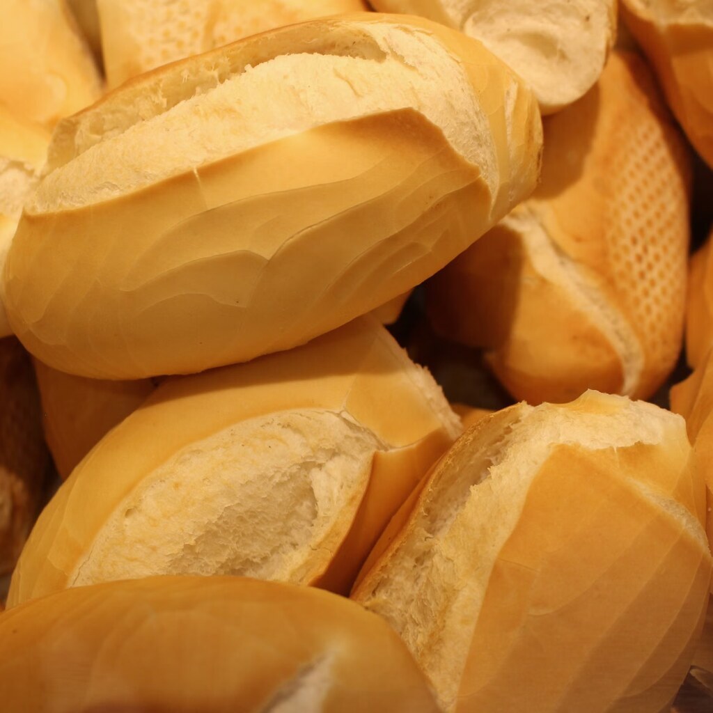 A photo of a pile of freshly baked bolillo bread rolls.