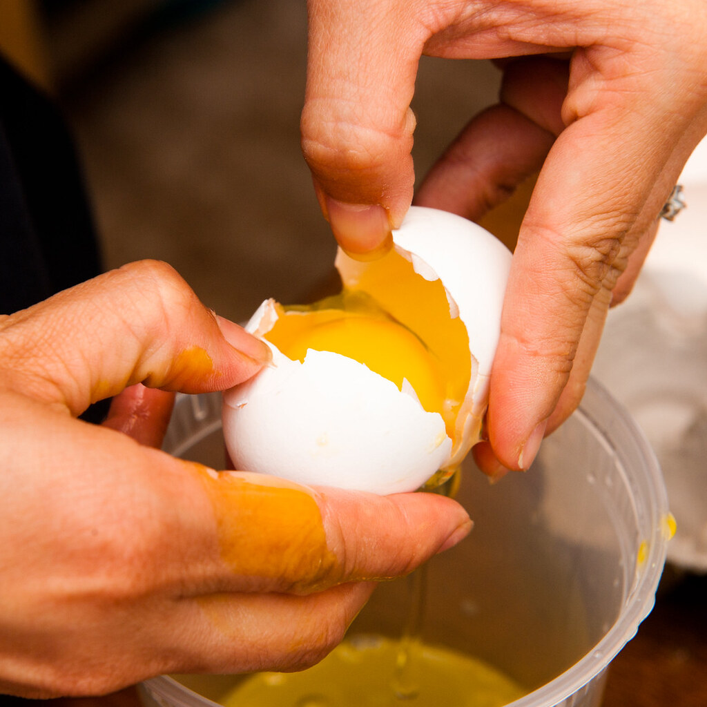 Photo of someone breaking an egg