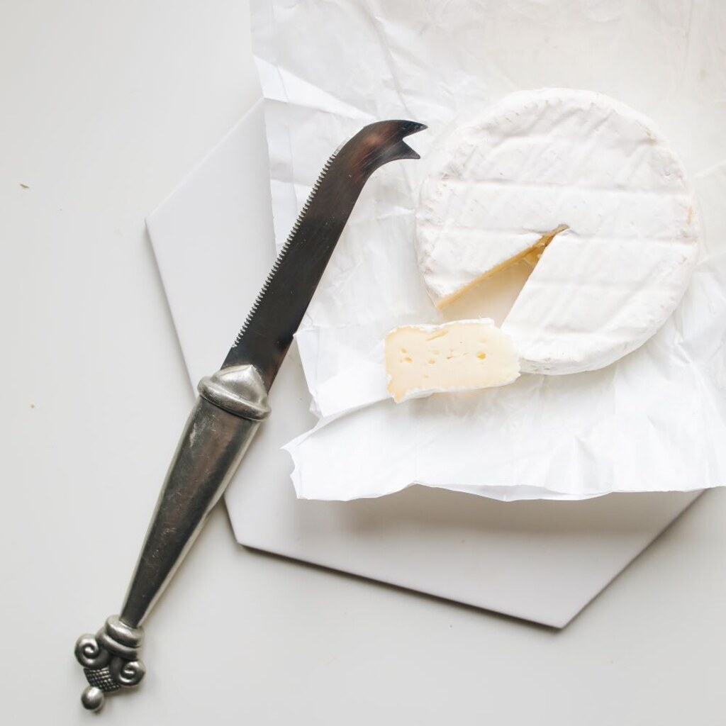 A wheel of Brie cheese with a wedge cut from it