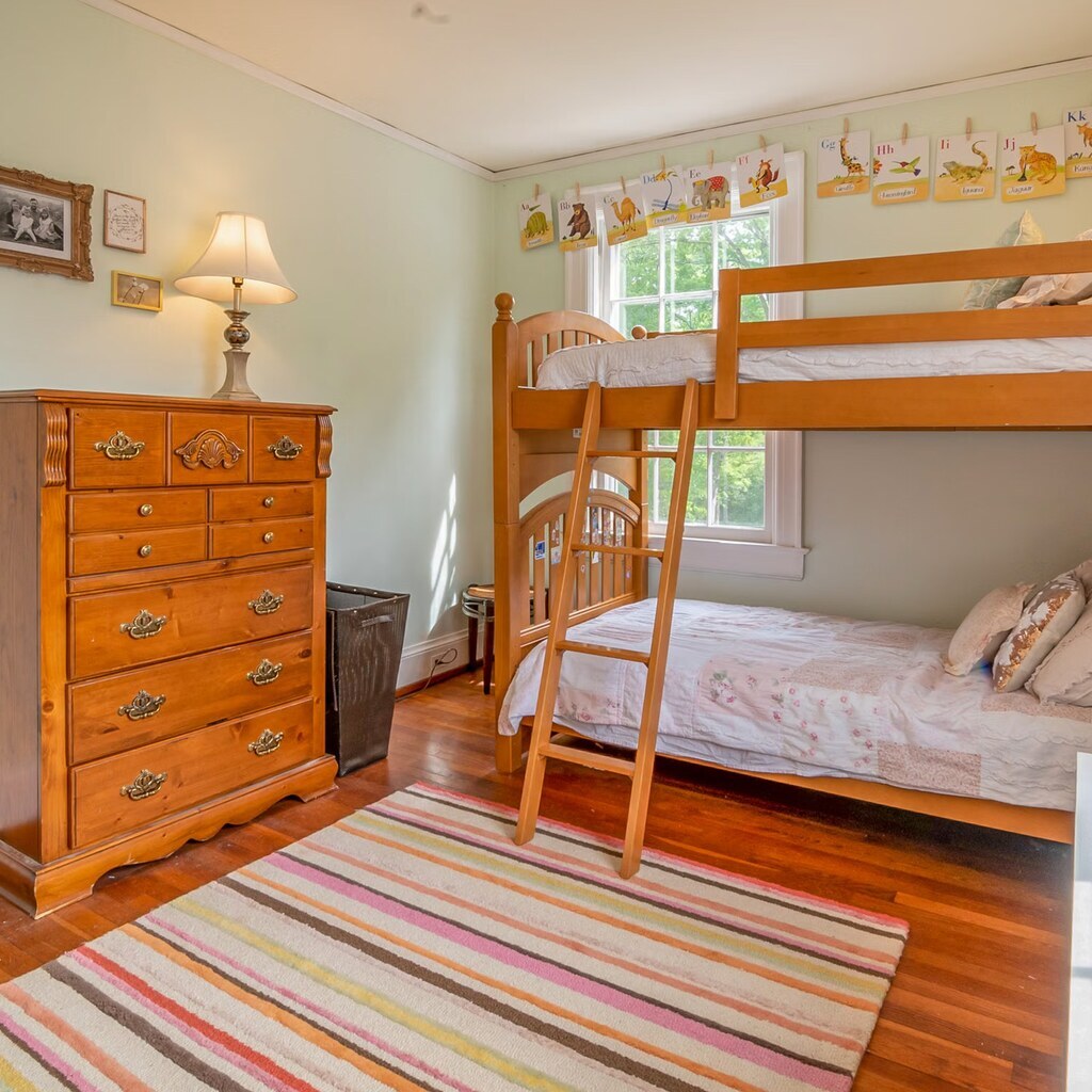 A photo of a wooden bunk bed with two stacked sleeping spaces and a ladder.