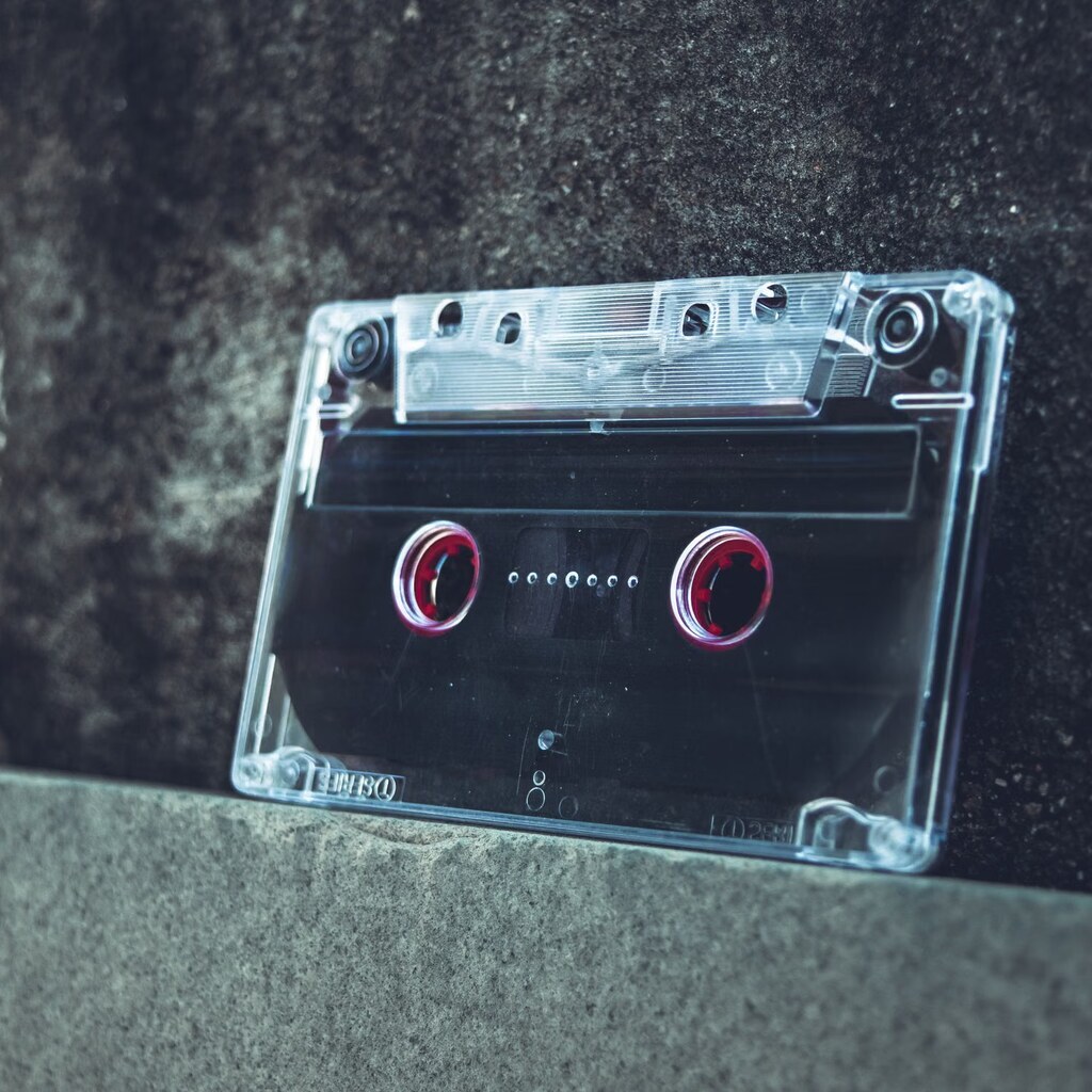 A photo of an audio cassette tape on a concrete surface.