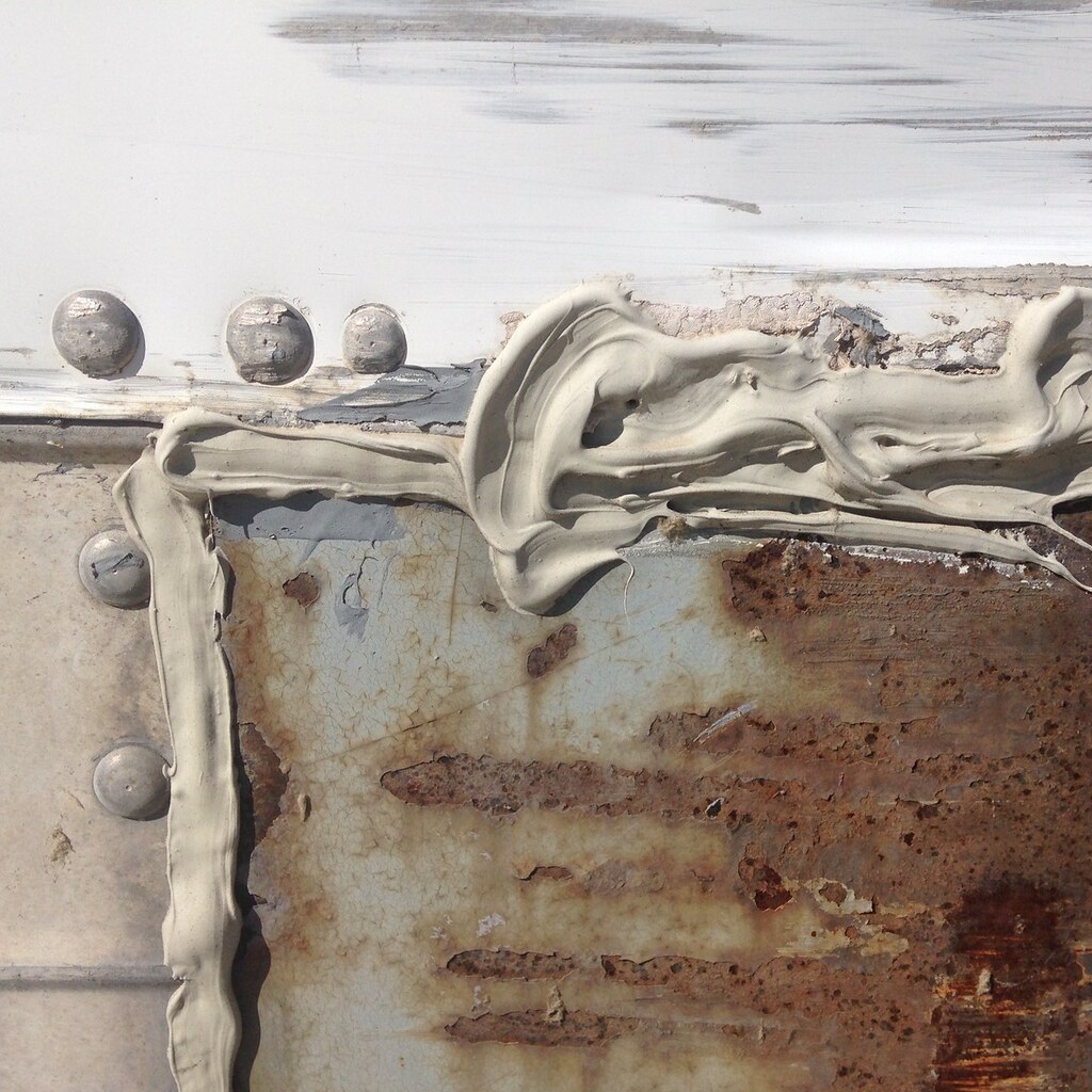 Caulk filling in rusted metal.
