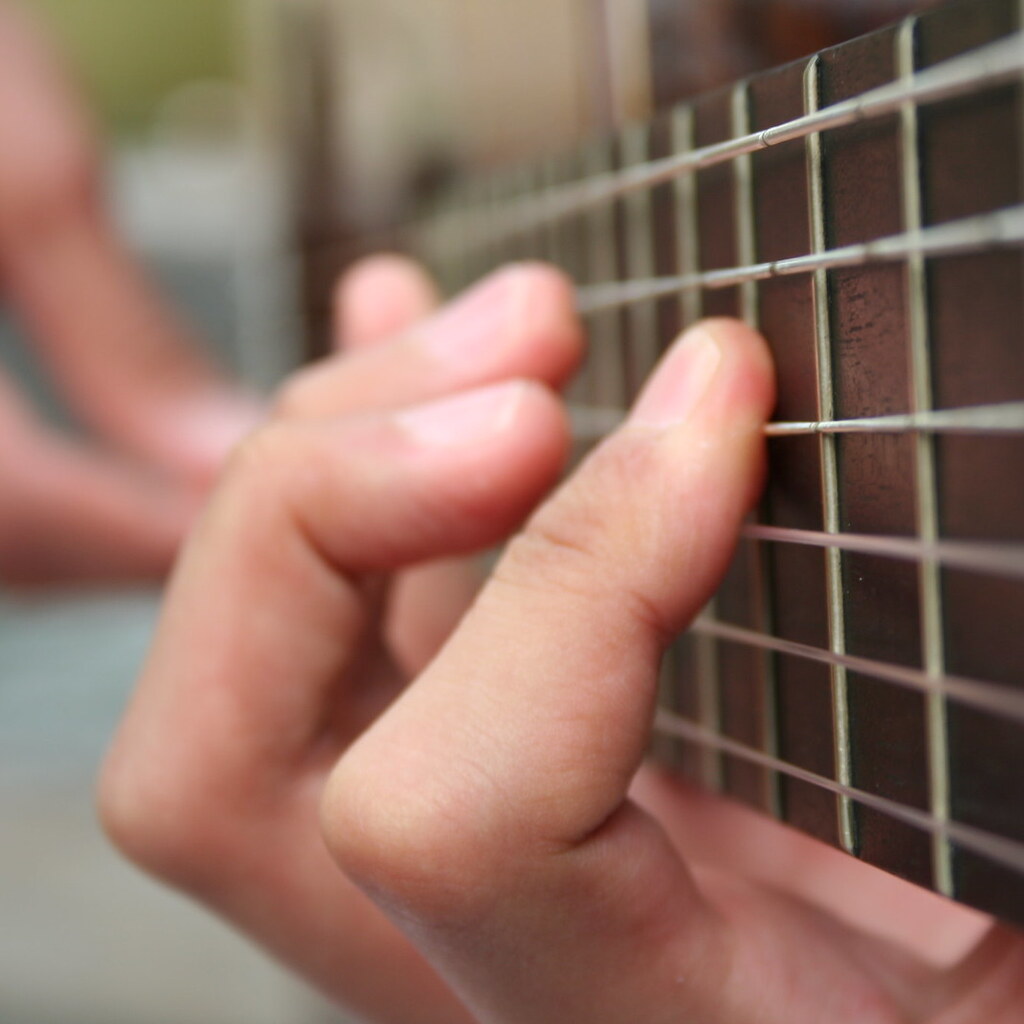 Photo of a man playing a guitar