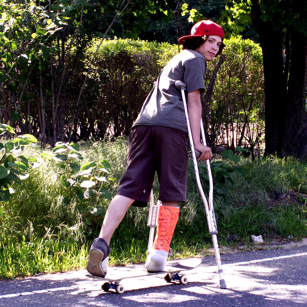 Photo of a boy on crutches ... and a skateboard
