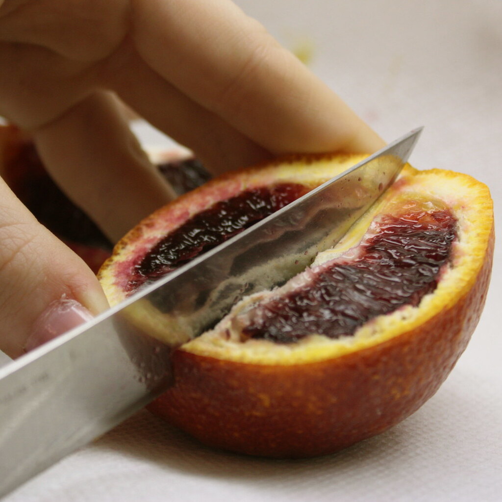 Photo of someone cutting a blood orange