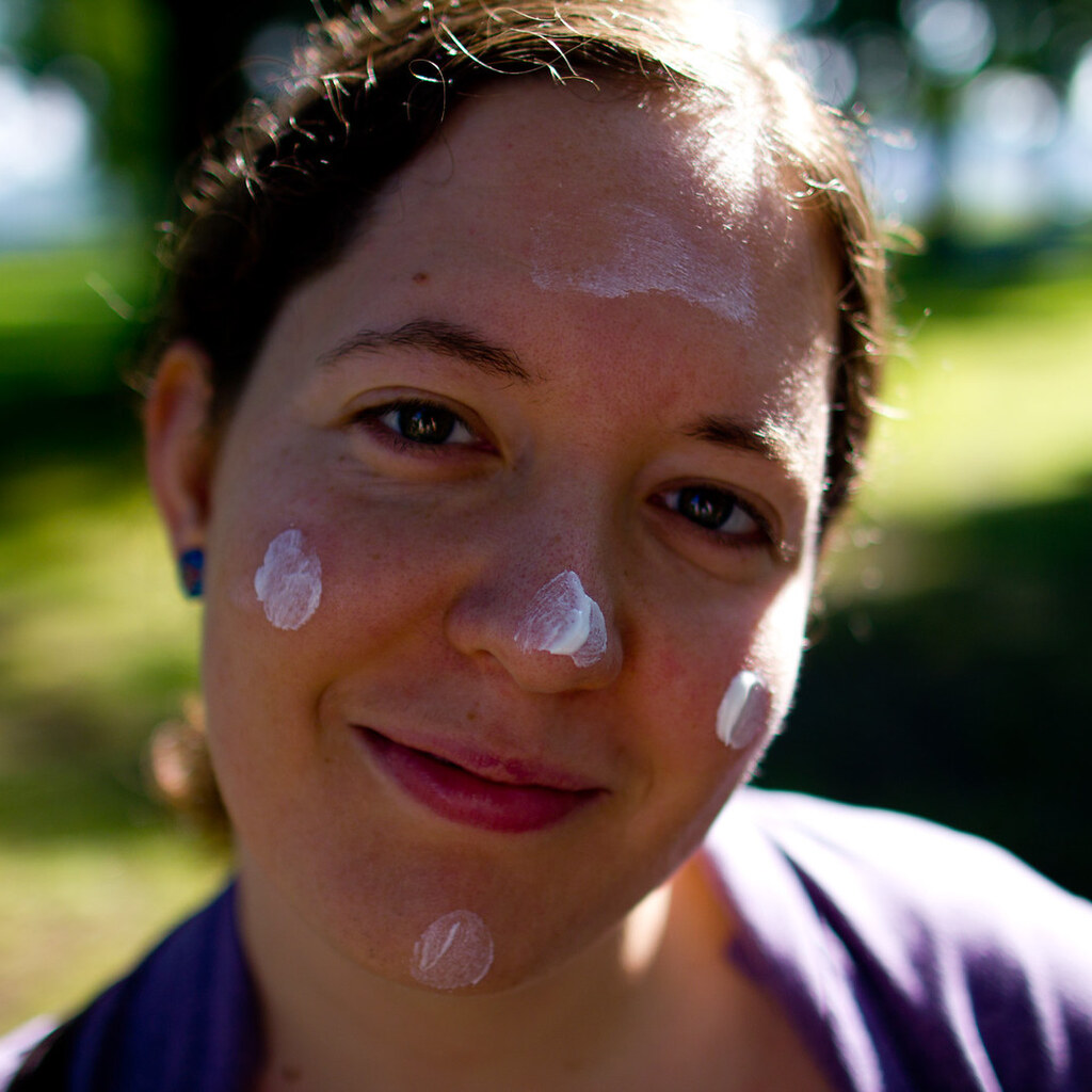 Photo of a woman with dabs of sunscreen on her face