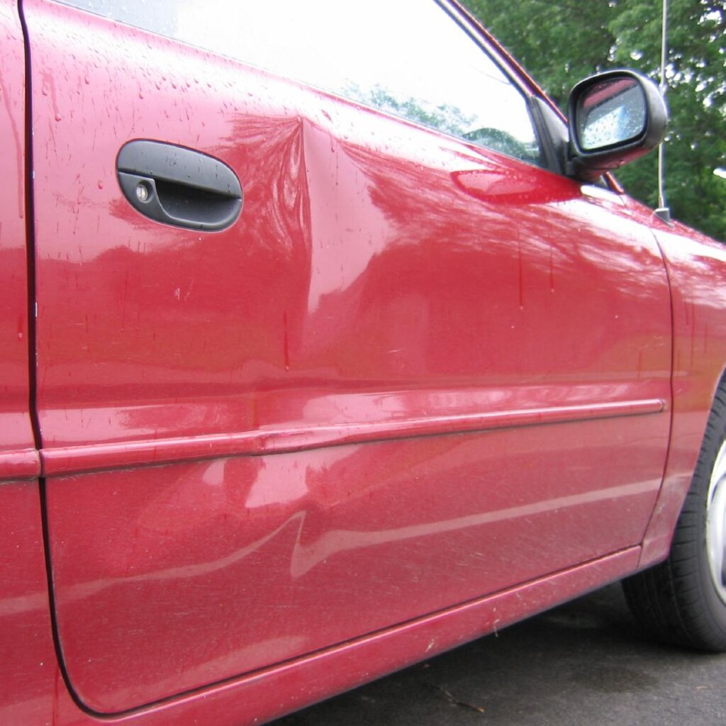 Photo of a car with a dent in the side