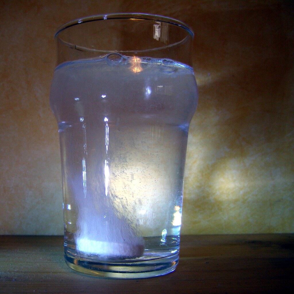 Photo of a tablet dissolving in a glass of water