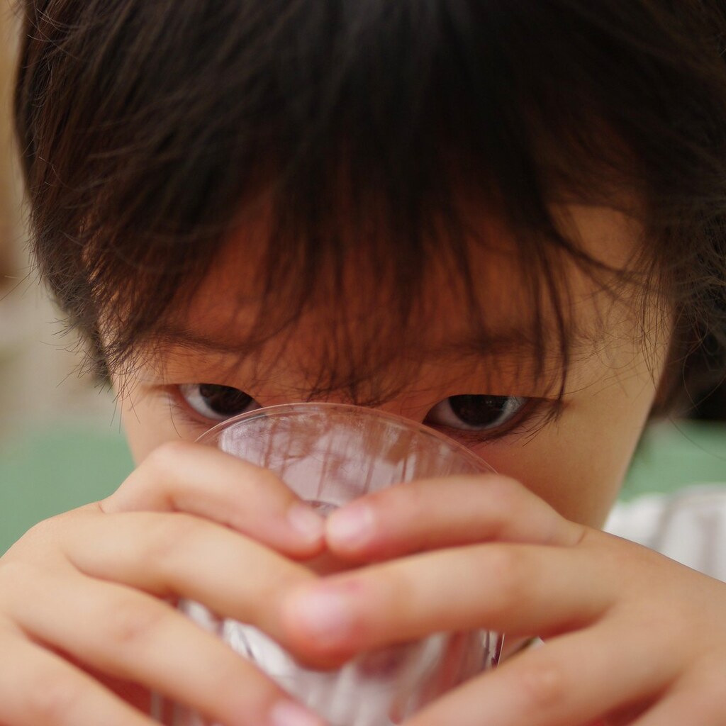 Photo of a child drinking a glass of water