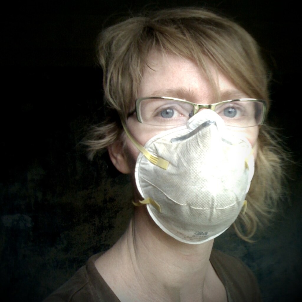 Photo of a woman wearing a dust mask.