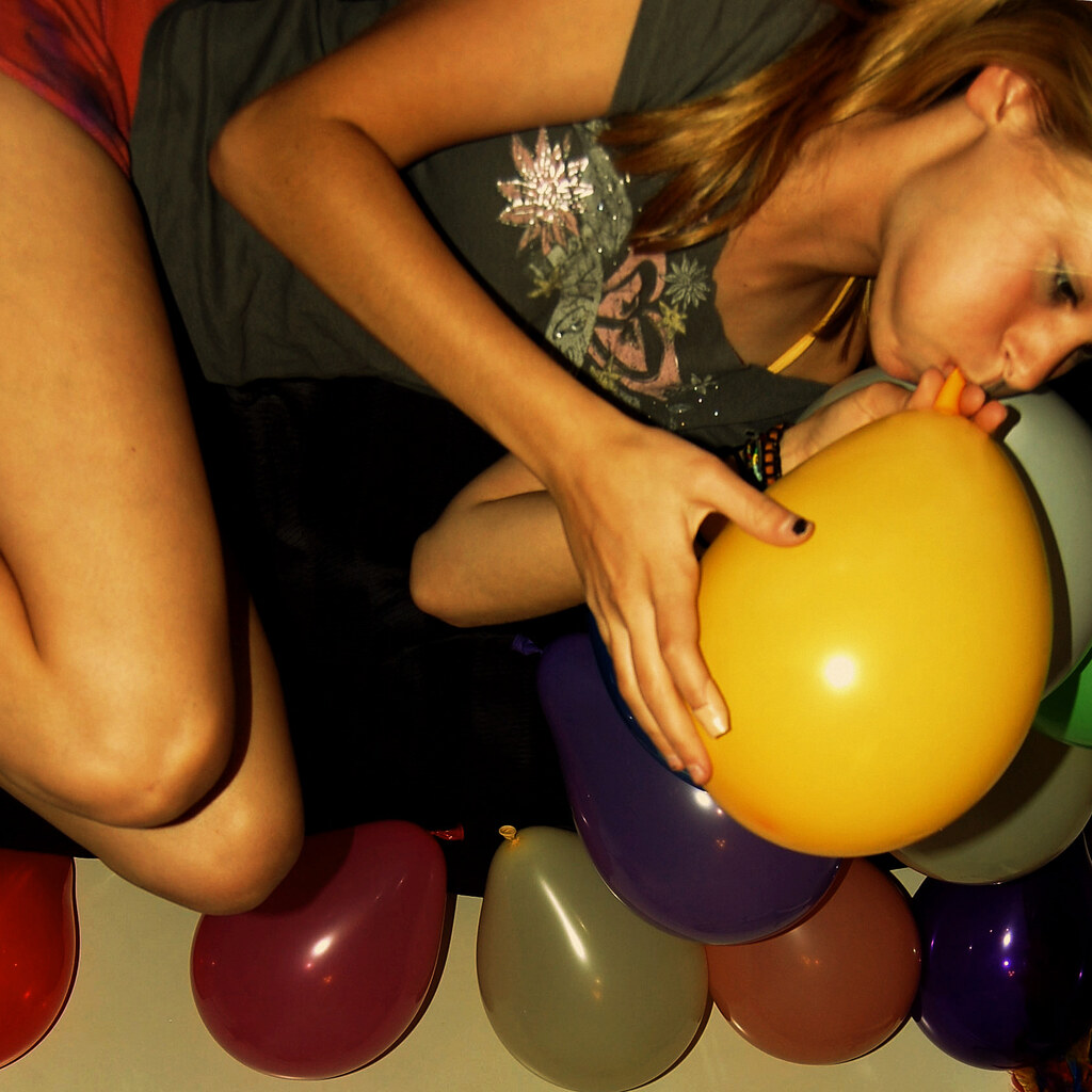 Photo of a girl blowing up a balloon