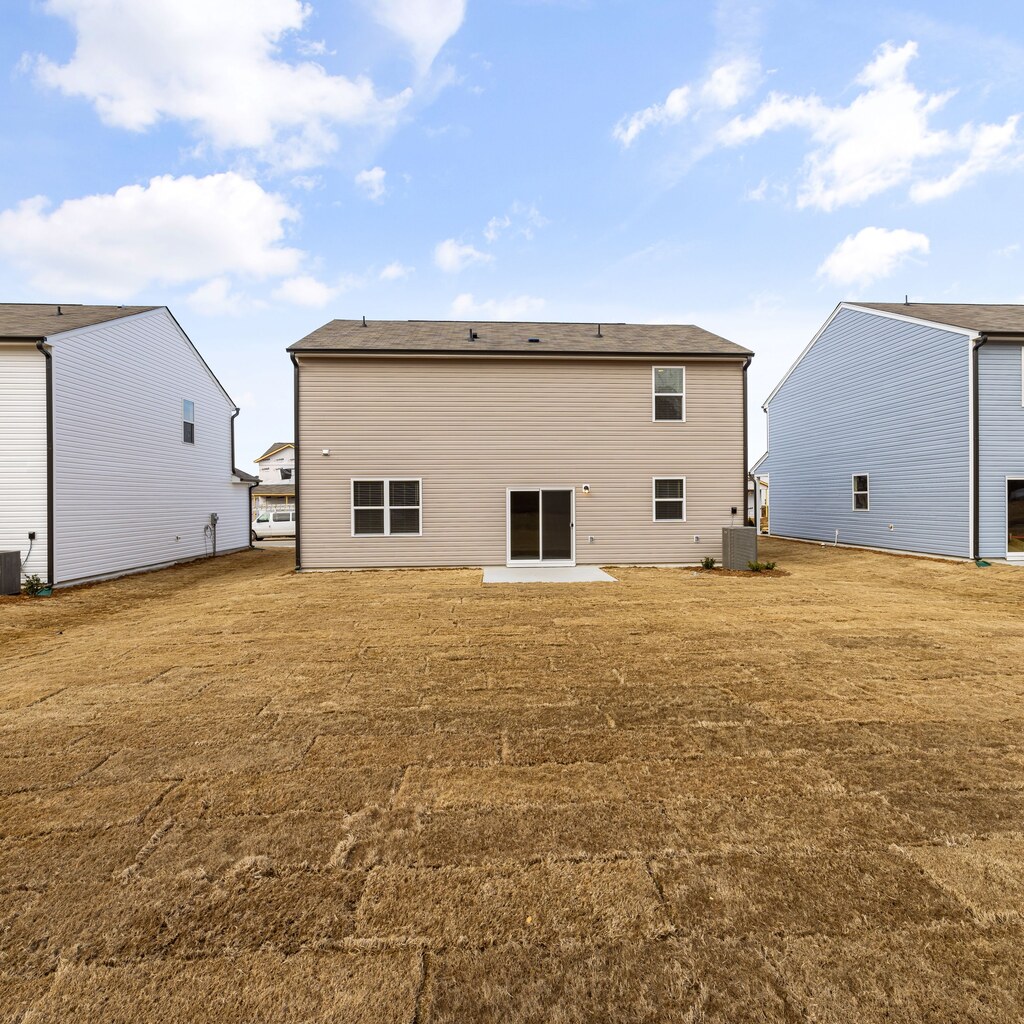 A photo of the exteriors of three suburban houses with lawns under a bright blue sky