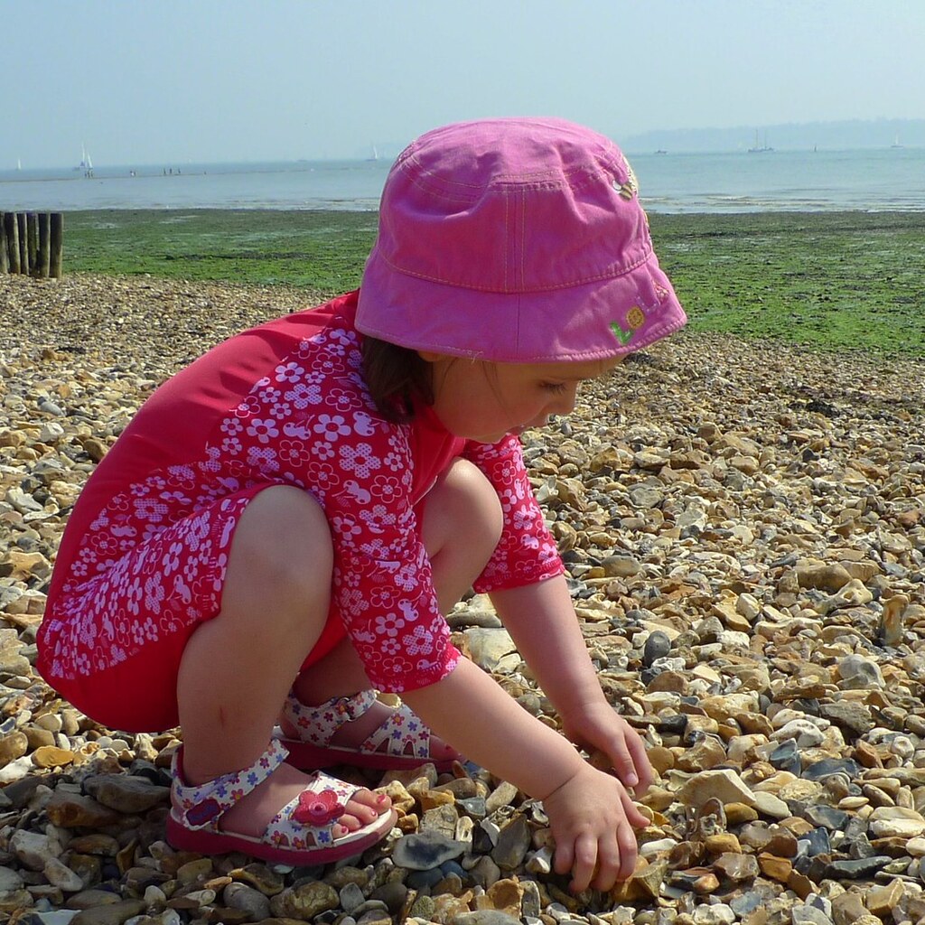 Photo of a little girl looking for shells