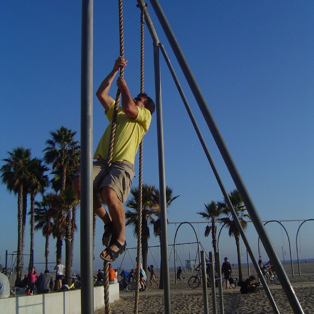 Photo of a man climbing a rope