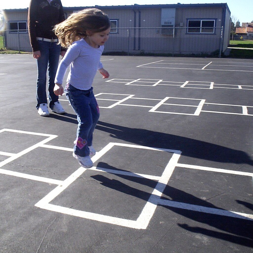 Photo of a child playing hopscotch