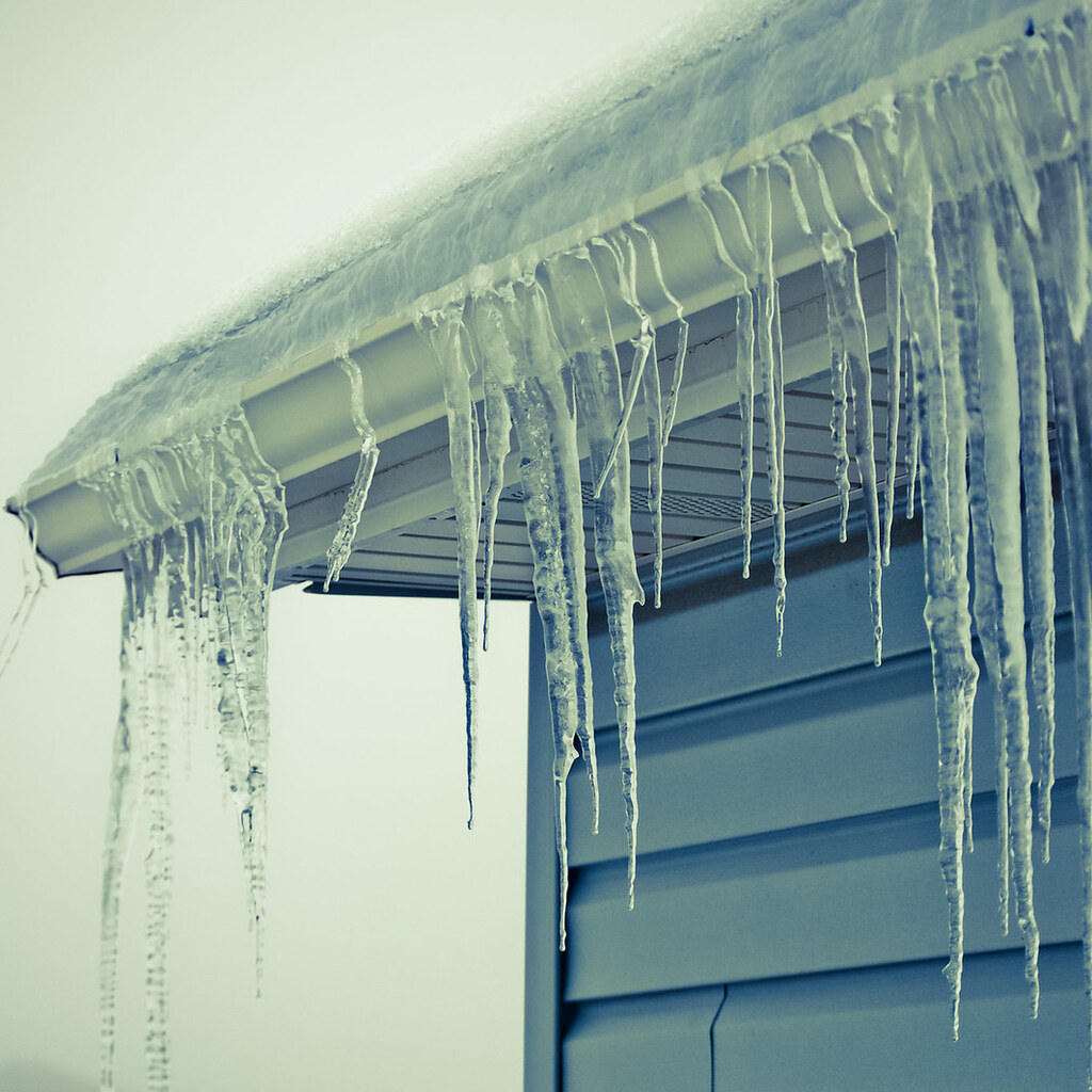 Photo of icicles hanging from the roof of a house.