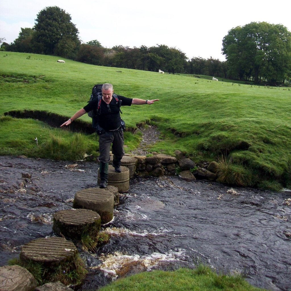 Photo of someone carefully crossing a creek