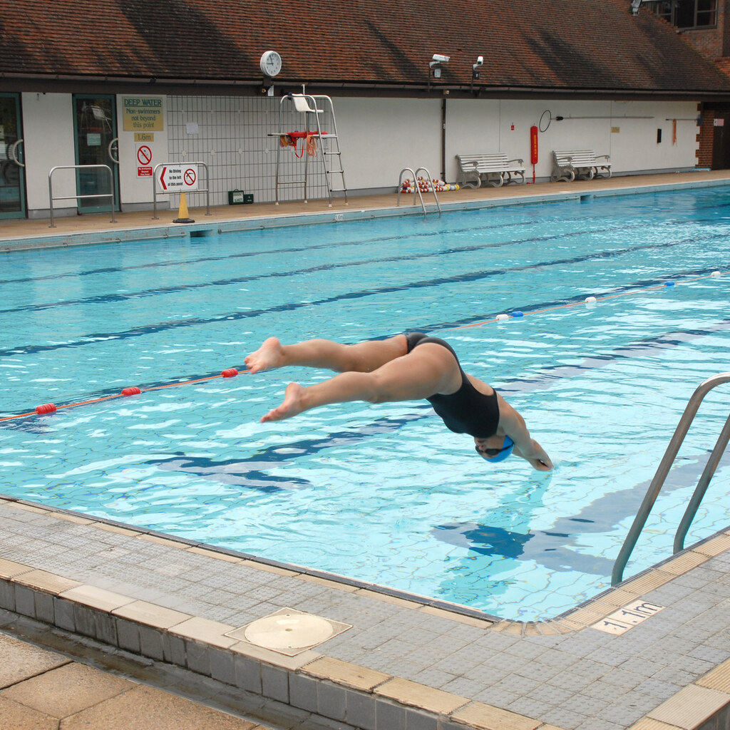 Photo of a girl diving into a pool