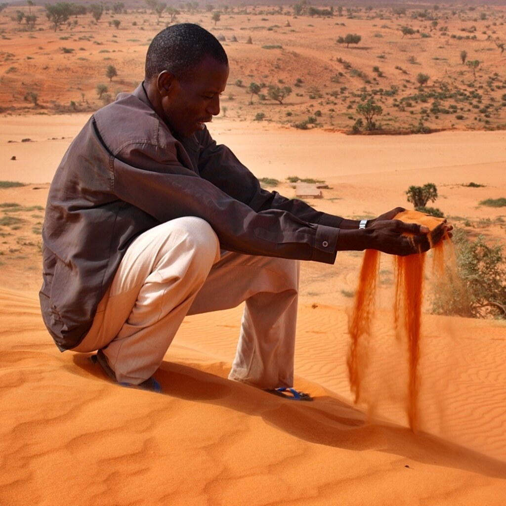 Photo of a man with sand slipping through his fingers