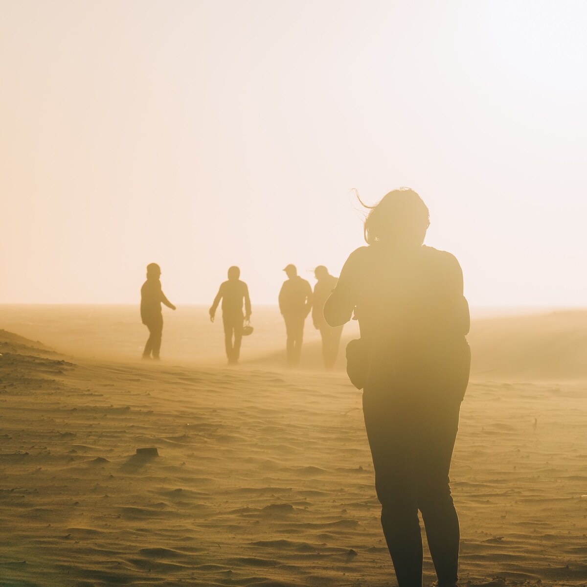 Photo of people walking in the dust