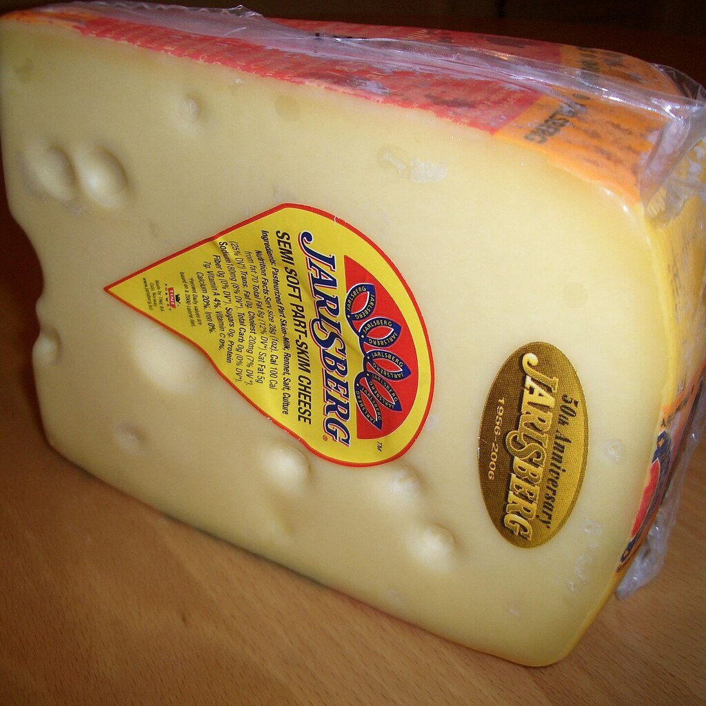 A photo of a wedge of Jarlsberg cheese with its characteristic holes.