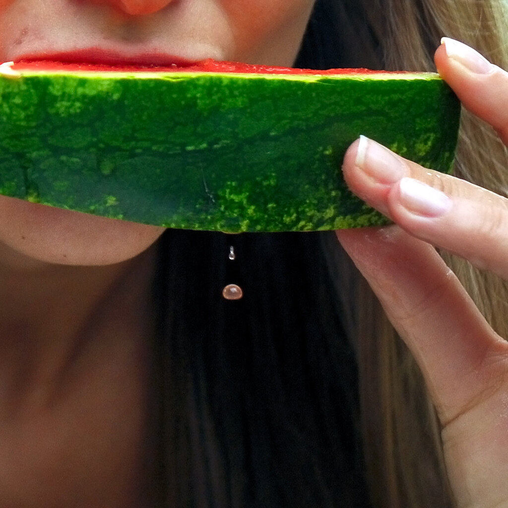 Photo of a girl eating a juicy watermelon