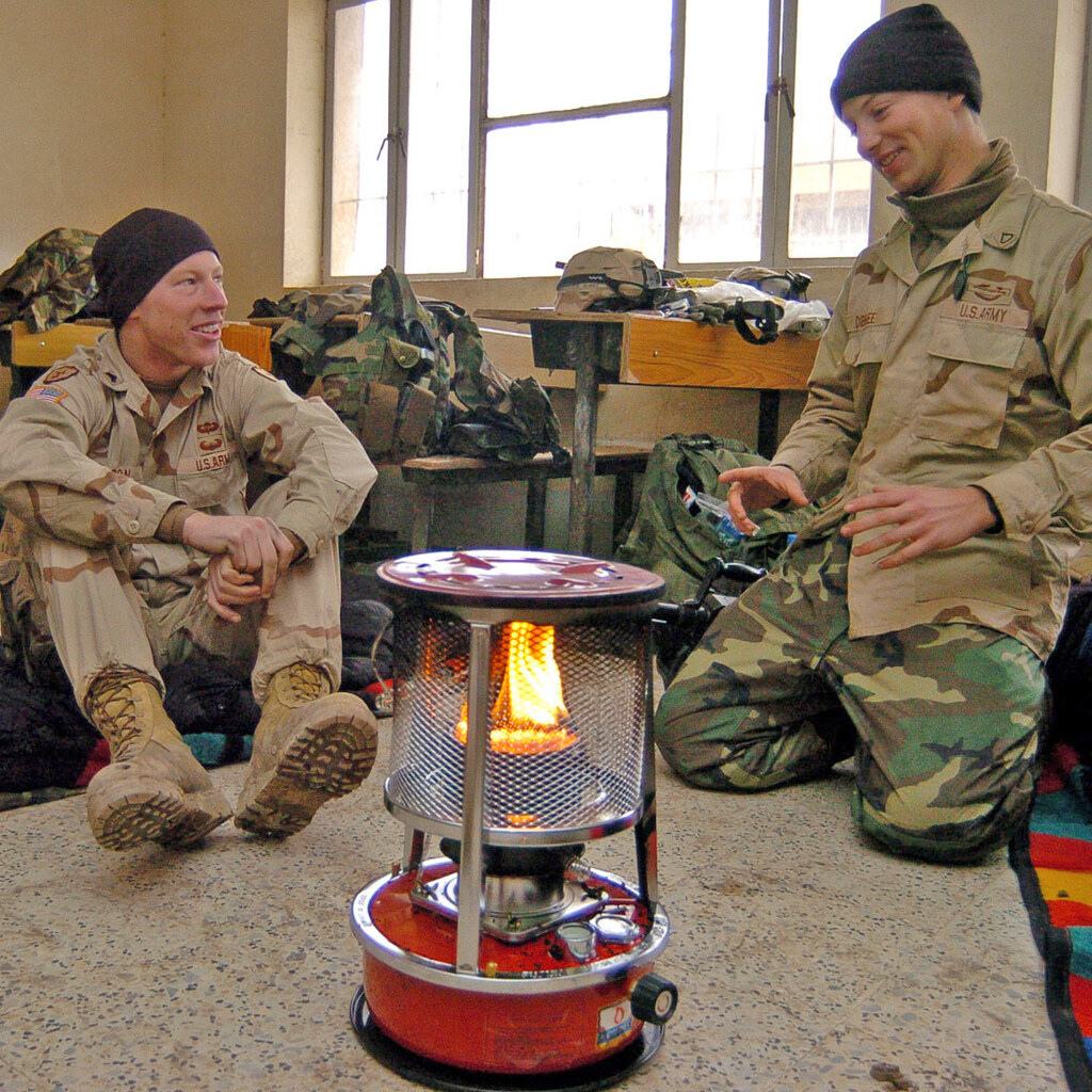 Photo of a soldiers around a kerosene heater