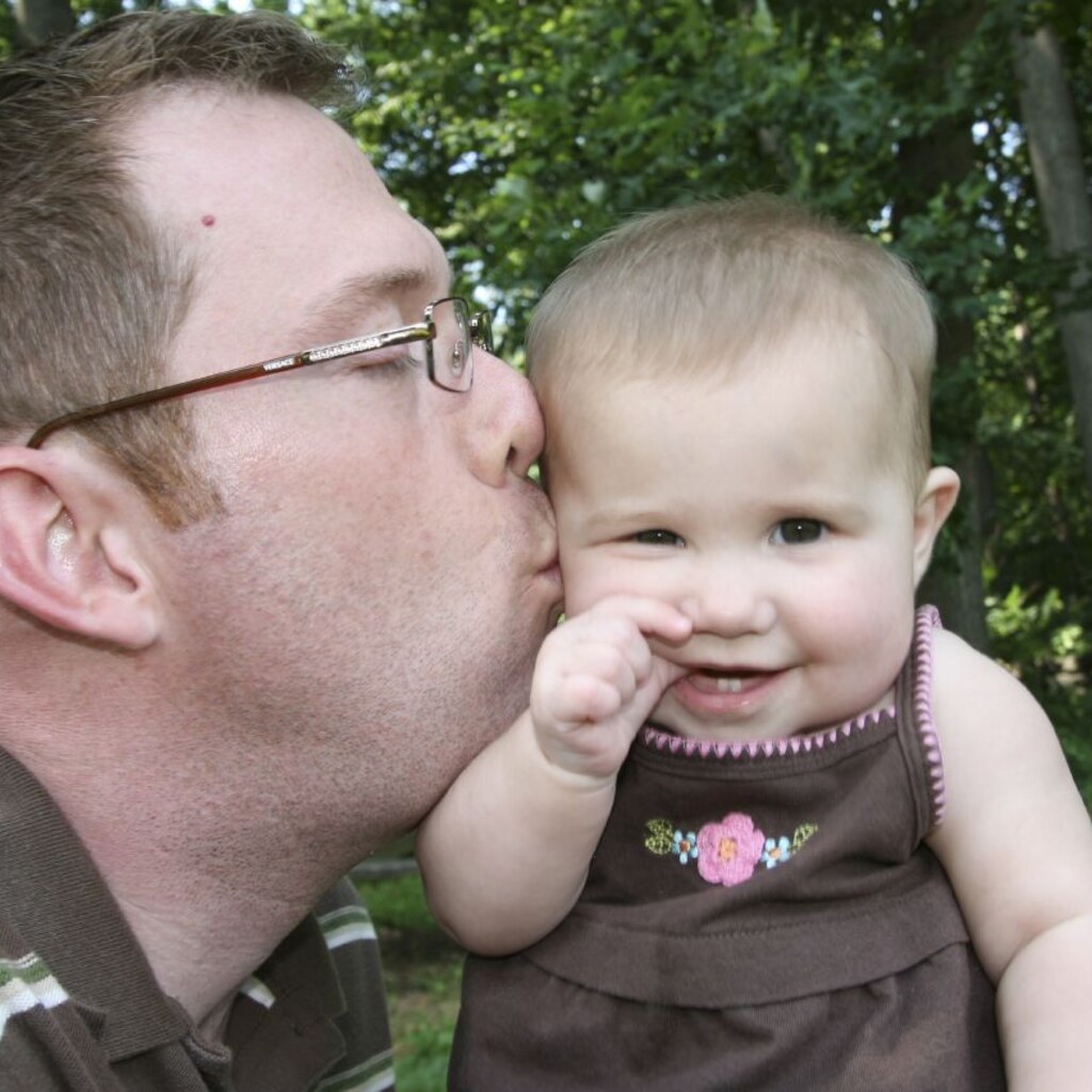 Photo of a man kissing a baby.